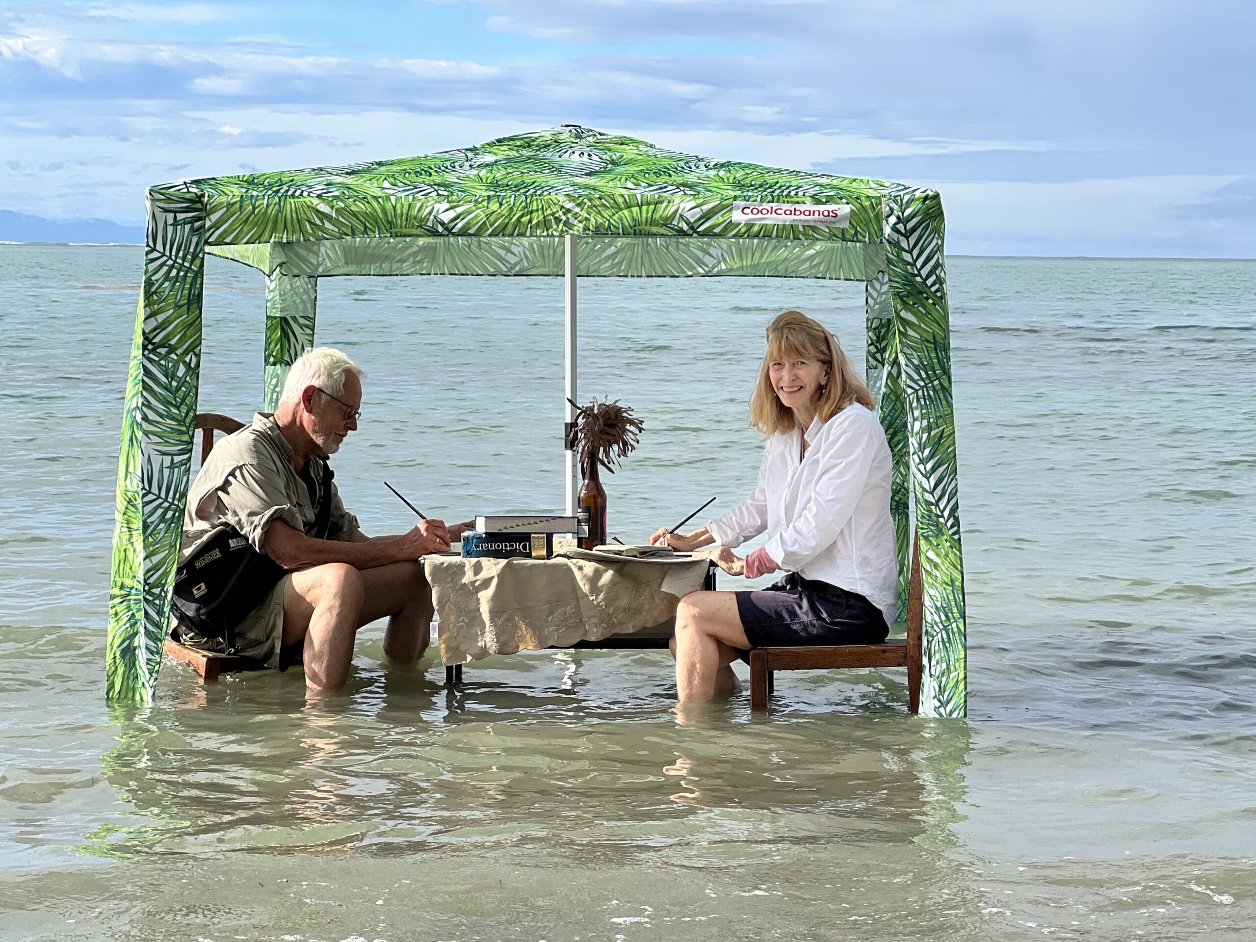 Susan and John writing as the tide comes in